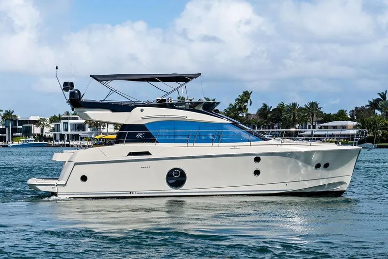 The Image of 2018 Monte Carlo MC 35 yacht cruising on a sunny day near luxury waterfront homes. - 0