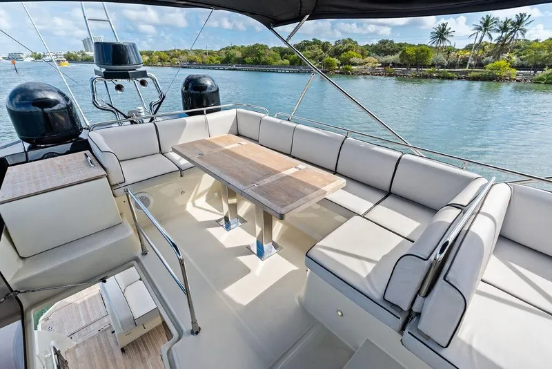 Slide: The Image of Luxurious 2018 Monte Carlo MC 35 yacht deck with seating and table, overlooking serene waterway. - 16