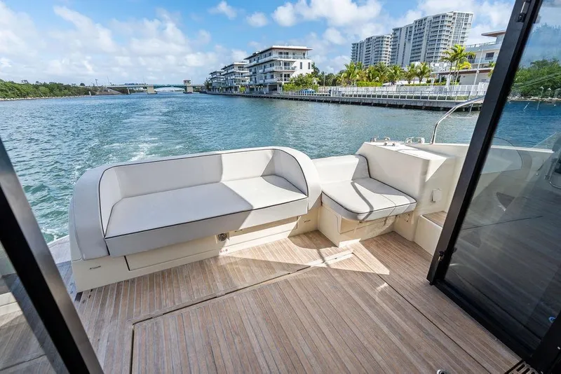 Slide: The Image of Luxurious Monte Carlo MC 35 yacht deck with seating, cruising near waterfront buildings, 2018 model. - 22