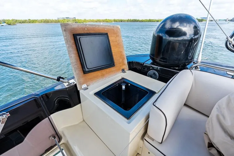 Slide: The Image of Luxury Monte Carlo MC 35 yacht interior with open storage compartment, 2018 model, on serene water. - 26