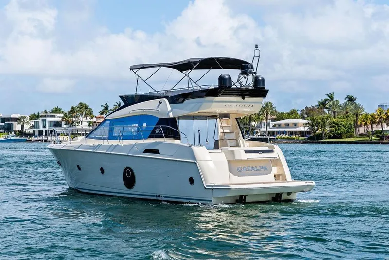 Slide: The Image of 2018 Monte Carlo MC 35 yacht cruising on a sunny day near luxury waterfront homes. - 5