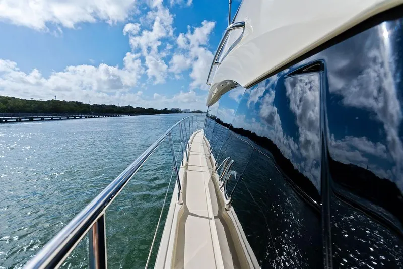 Slide: The Image of Sleek Monte Carlo MC 35 yacht cruising on a sunny day, reflecting blue skies and clouds. - 54