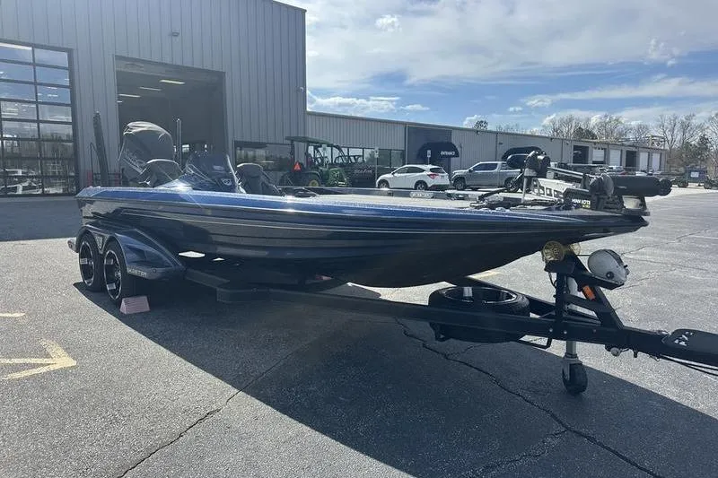 Slide: The Image of 2020 Skeeter FXR21 boat on trailer outside dealership under cloudy sky. - 4