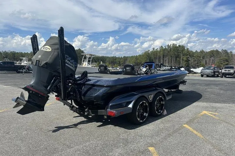 Slide: The Image of 2020 Skeeter FXR21 boat on trailer in parking lot under blue sky. - 5