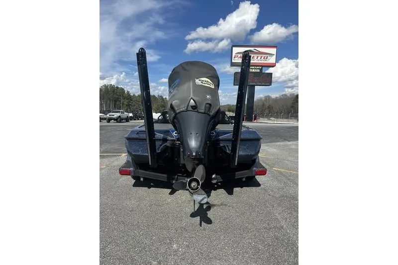 Slide: The Image of 2020 Skeeter FXR21 boat with outboard motor, parked outdoors under a cloudy sky. - 6