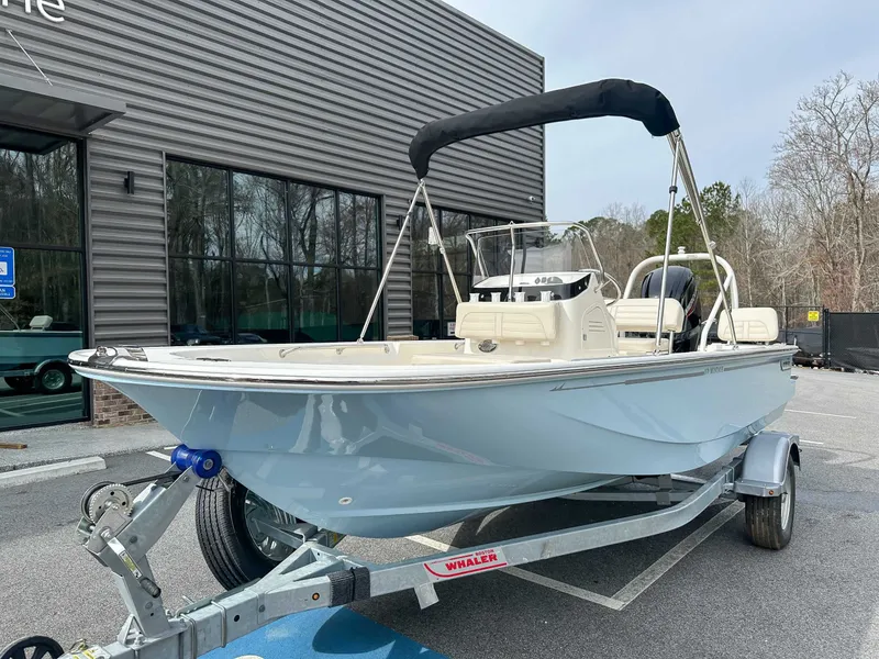 Slide: The Image of 2025 Boston Whaler 170 Montauk boat on trailer outside building. - 3