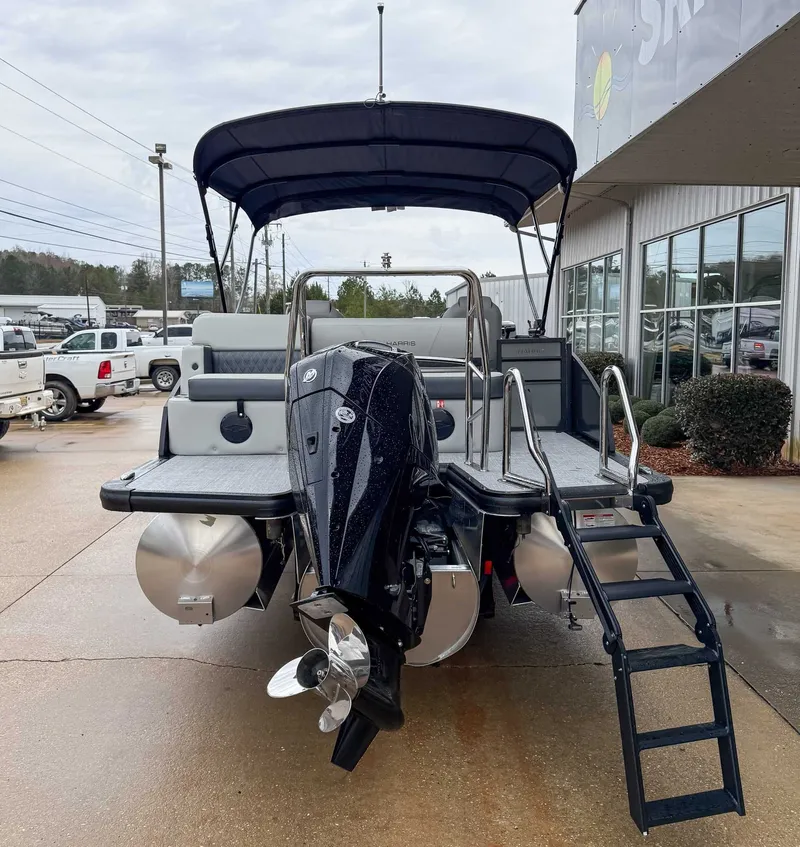 Slide: The Image of 2026 Harris Cruiser 230 SLDH with outboard motor and ladder, parked outdoors. - 9