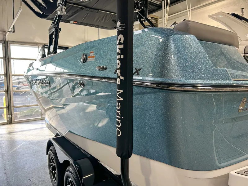 Slide: The Image of 2025 Moomba Max boat in a garage, shiny blue finish. - 7