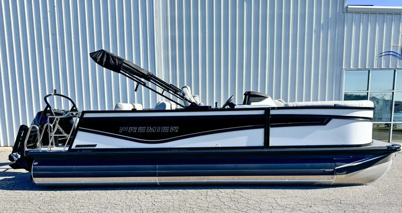 The Image of 2026 Premier Intrigue 230 RL pontoon boat side view by building. - 1