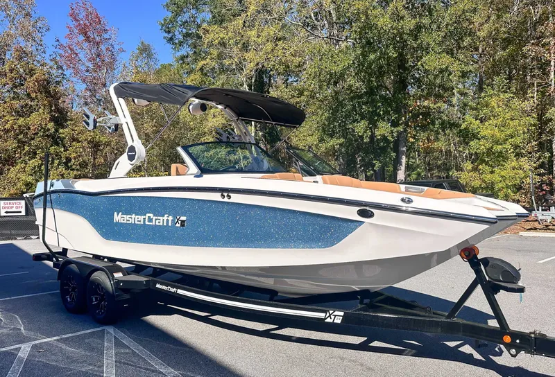 Slide: The Image of 2026 MasterCraft XT24 boat parked on trailer outdoors. - 3