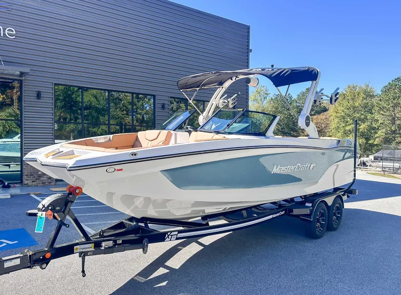Slide: The Image of 2026 MasterCraft XT24 boat on trailer outside building. - 5