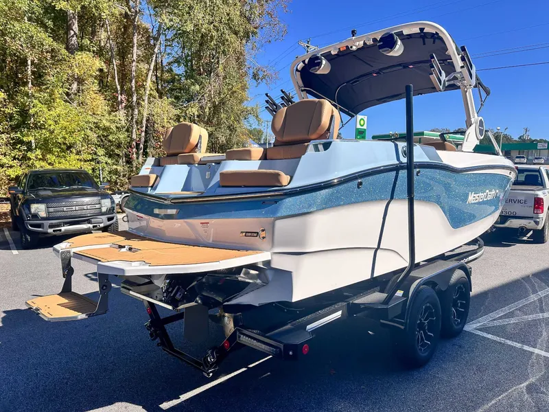 Slide: The Image of 2026 MasterCraft XT24 boat parked outdoors on a trailer. - 8