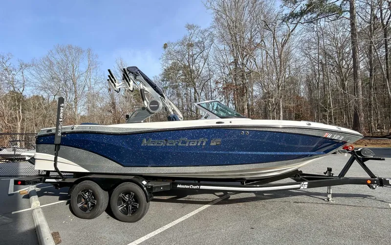 The Image of 2020 MasterCraft XT23 boat parked on trailer outdoors. - 1