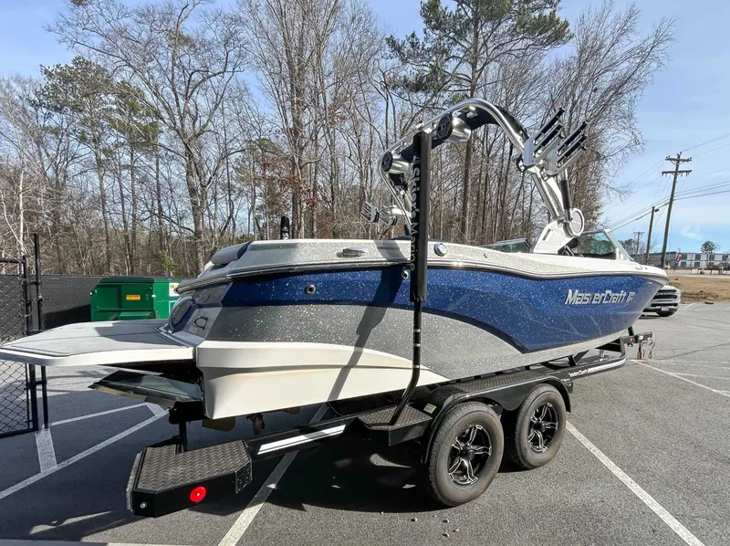 Slide: The Image of 2020 MasterCraft XT23 boat parked on trailer outdoors. - 7