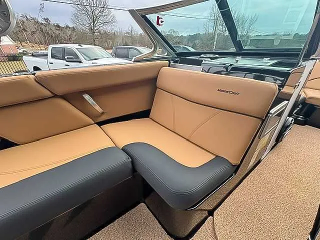 Slide: The Image of 2018 MasterCraft XT22 boat interior with tan and black seating. - 13