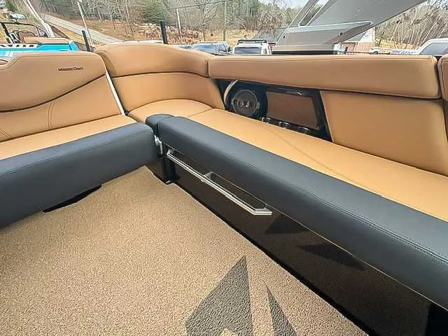 Slide: The Image of Interior of a 2018 MasterCraft XT22 boat with brown and black seating. - 19