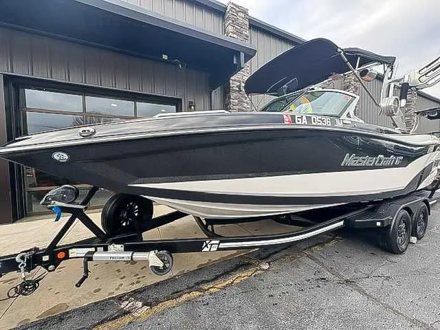 Slide: The Image of 2018 MasterCraft XT22 boat on trailer outside building. - 3