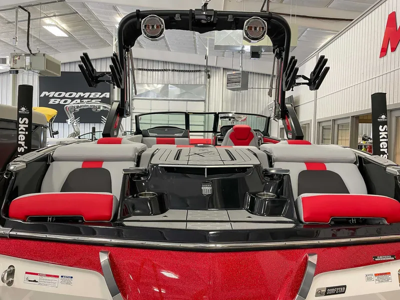 Slide: The Image of MasterCraft X22 2022 boat with red and gray interior in a showroom. - 8