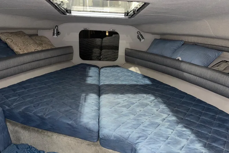 Slide: The Image of Interior cabin of 1992 Chaparral Signature 30 boat with blue bedding and pillows. - 28