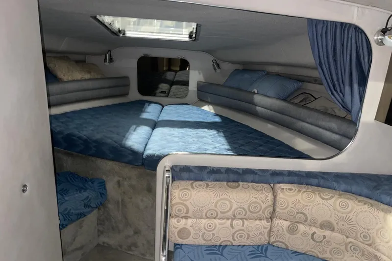 Slide: The Image of 1992 Chaparral Signature 30 cabin interior with blue bedding and cozy seating area. - 29