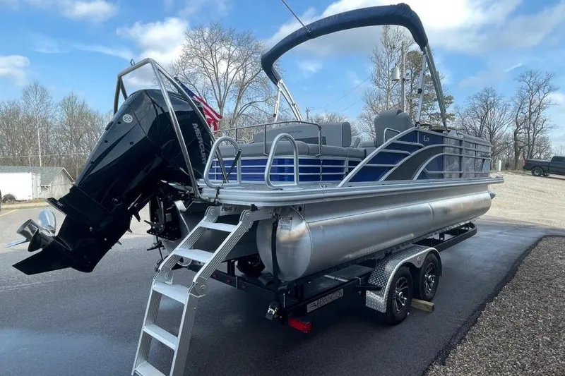 Slide: The Image of 2024 Bennington 23 LSB pontoon boat on trailer, featuring a powerful outboard motor. - 5