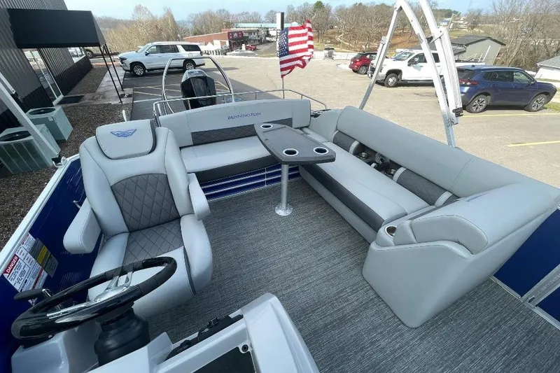 Slide: The Image of 2024 Bennington 23 LSB pontoon boat interior with plush seating and steering console. - 7