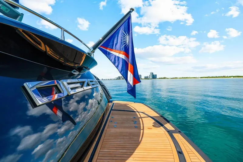 Slide: The Image of Sunseeker Predator 84 yacht, 2010 model, with flag, reflecting blue sky and clouds. - 64