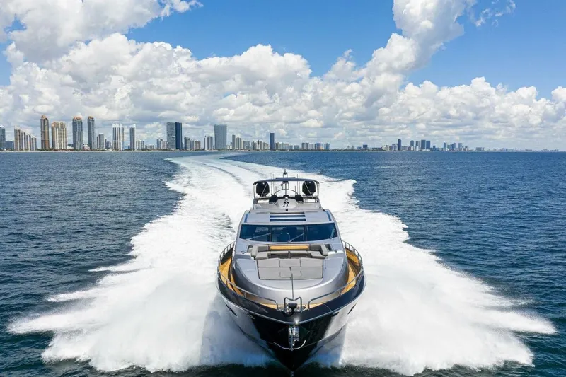 Slide: The Image of Sunseeker Predator 84 yacht cruising near city skyline under blue sky, 2010 model. - 66