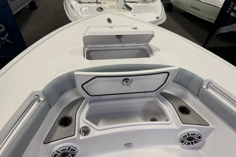 Slide: The Image of 2026 Sportsman Masters 267OE Bay Boat interior with open storage compartments and cup holders. - 2