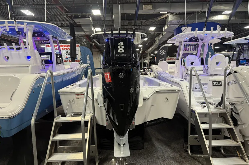 Slide: The Image of 2026 Sportsman Masters 267OE Bay Boat displayed at a boat show with powerful engine. - 8