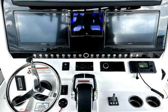 Slide: The Image of 2023 Fountain 38 Tournament Edition boat dashboard with dual screens and steering wheel. - 21
