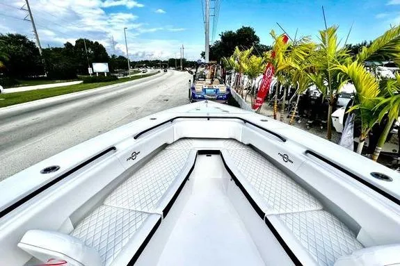 Slide: The Image of 2023 Fountain 38 Tournament Edition boat with white seating, parked near a road and palm trees. - 47