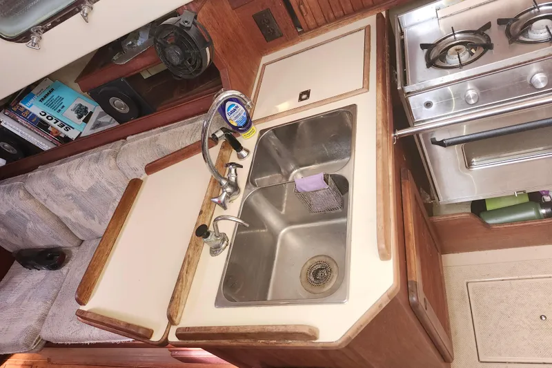 Slide: The Image of 1994 Island Packet 32 yacht kitchen with sink, stove, and storage. - 11
