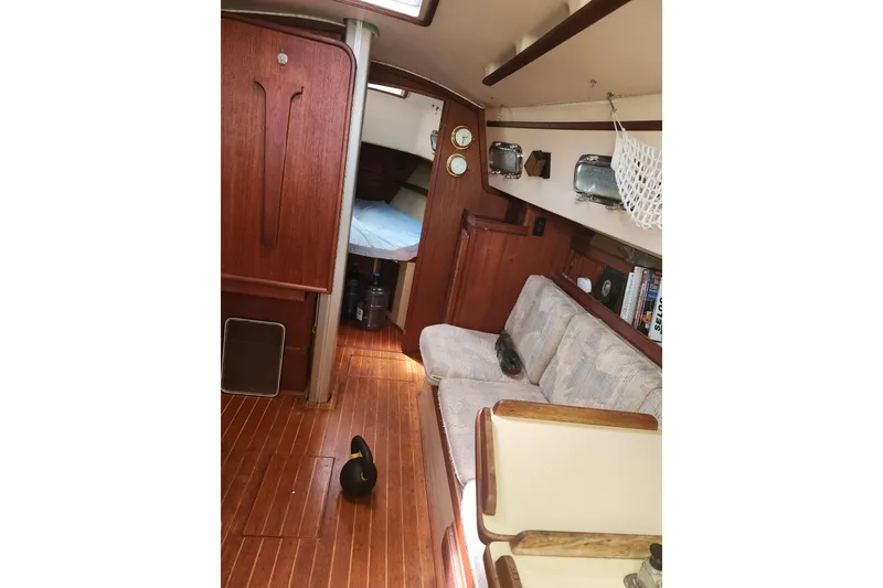 Slide: The Image of Interior of a 1994 Island Packet 32 sailboat with wood finish and cozy seating. - 13