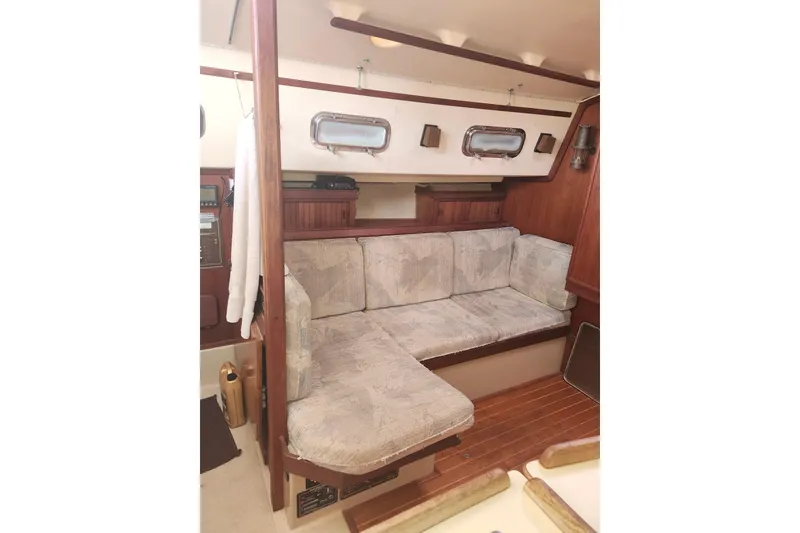Slide: The Image of Interior of 1994 Island Packet 32 sailboat with cushioned seating and wooden accents. - 15