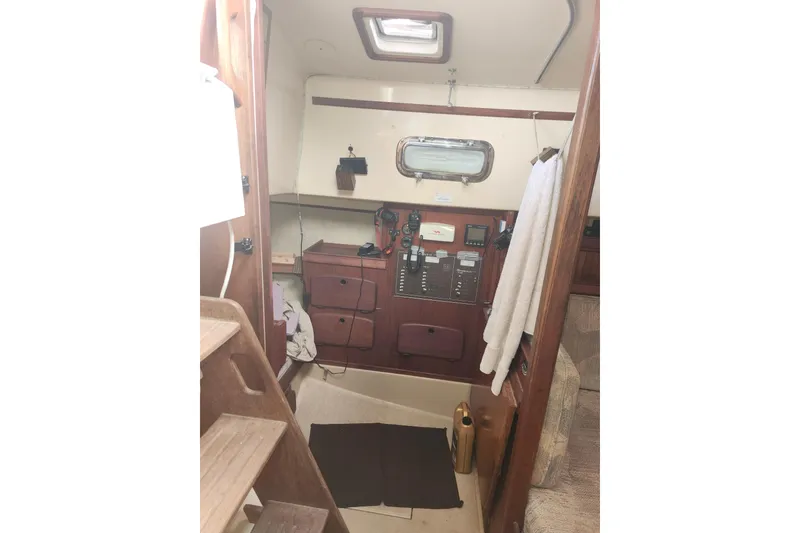 Slide: The Image of Interior of 1994 Island Packet 32 sailboat with wooden cabinetry and navigation equipment. - 17