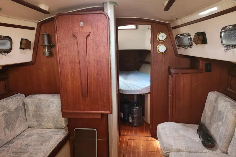 Slide: The Image of Interior of a 1994 Island Packet 32 sailboat with cozy seating and wooden finishes. - 18