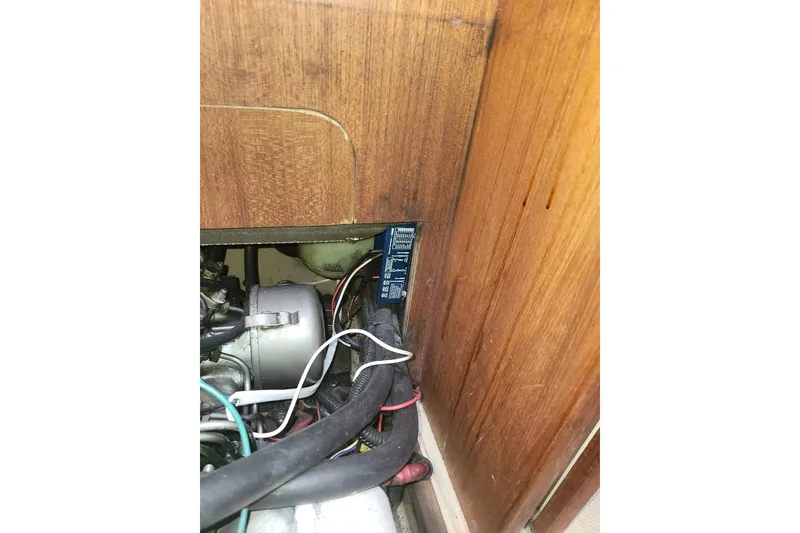 Slide: The Image of Engine compartment of a 1994 Island Packet 32 sailboat, showing wiring and components. - 21