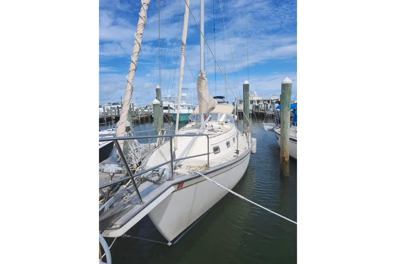 Slide: The Image of 1994 Island Packet 32 sailboat docked at marina under blue sky. - 5