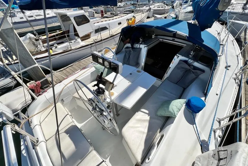 Slide: The Image of 1999 Catalina 36 MkII sailboat cockpit with blue canopy, docked at marina. - 16