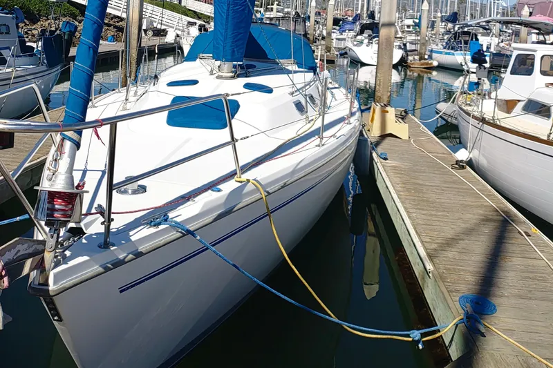 Slide: The Image of 1999 Catalina 36 MkII sailboat docked in a marina, featuring blue covers and sleek design. - 2