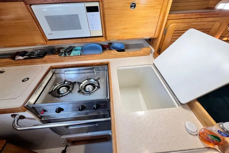 Slide: The Image of 1999 Catalina 36 MkII yacht kitchen with stove, microwave, and sink. - 27
