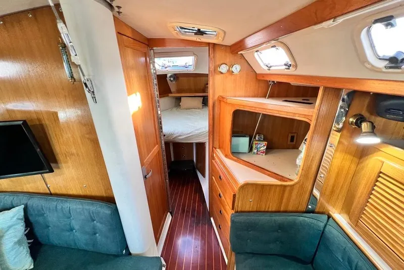 Slide: The Image of Interior of a 1999 Catalina 36 MkII sailboat, featuring wood paneling and cozy cabin space. - 33