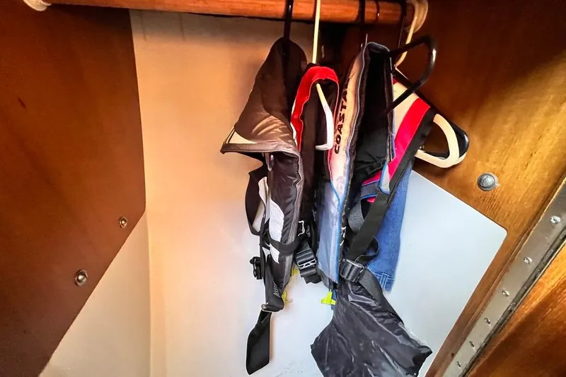 Slide: The Image of Life jackets hanging in a 1999 Catalina 36 MkII sailboat closet. - 51