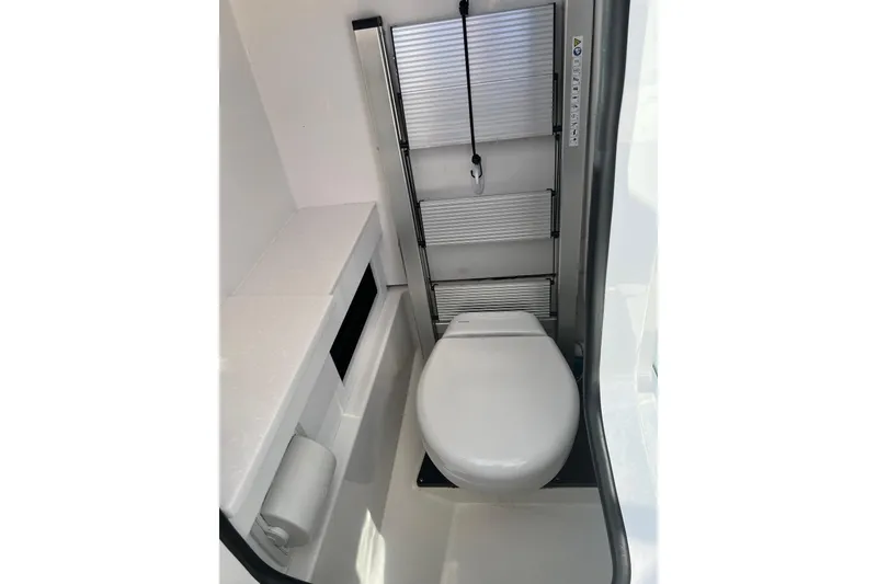 Slide: The Image of 2021 Blackfin 252 DC boat interior with compact toilet and storage ladder. - 10