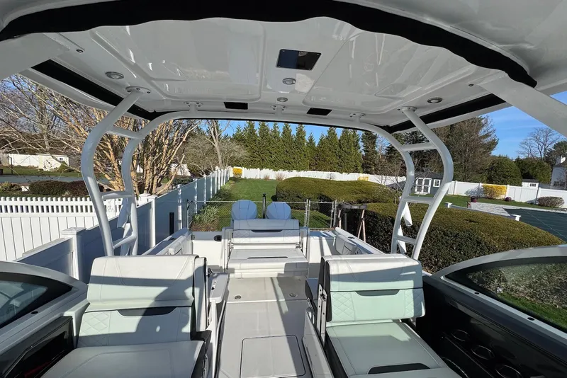 Slide: The Image of 2021 Blackfin 252 DC boat interior with seating, white upholstery, and open deck view. - 15