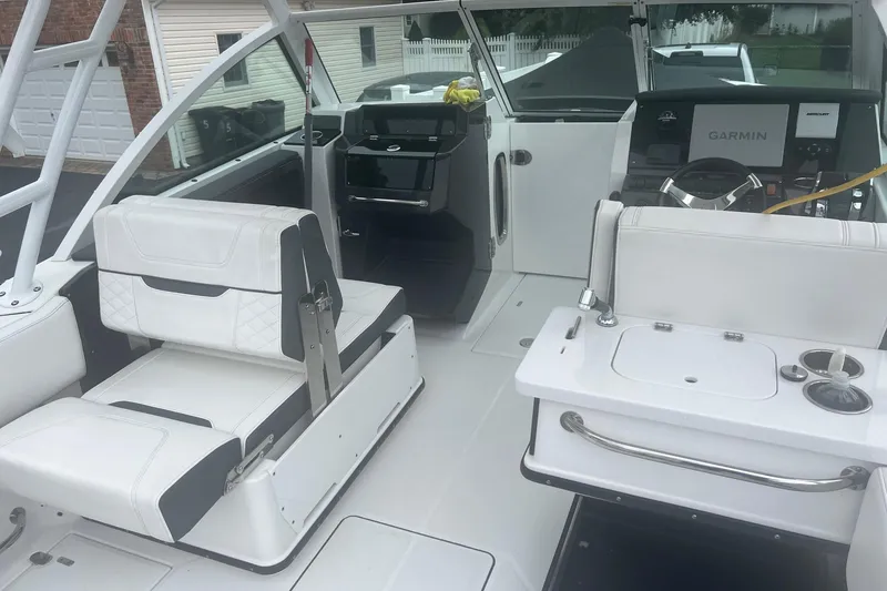 Slide: The Image of 2021 Blackfin 252 DC boat interior with white seating and Garmin navigation system. - 2