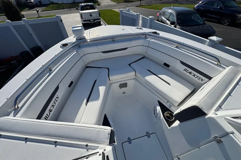 Slide: The Image of 2021 Blackfin 252 DC boat with spacious seating and sleek design in a driveway setting. - 23