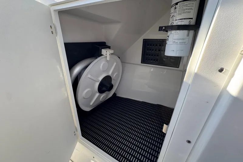 Slide: The Image of Storage compartment in a 2021 Blackfin 252 DC boat with hose reel and fire extinguisher. - 33