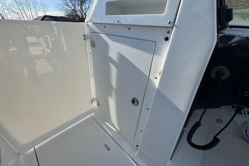 Slide: The Image of 2021 Blackfin 252 DC boat interior with storage compartment and control panel. - 34